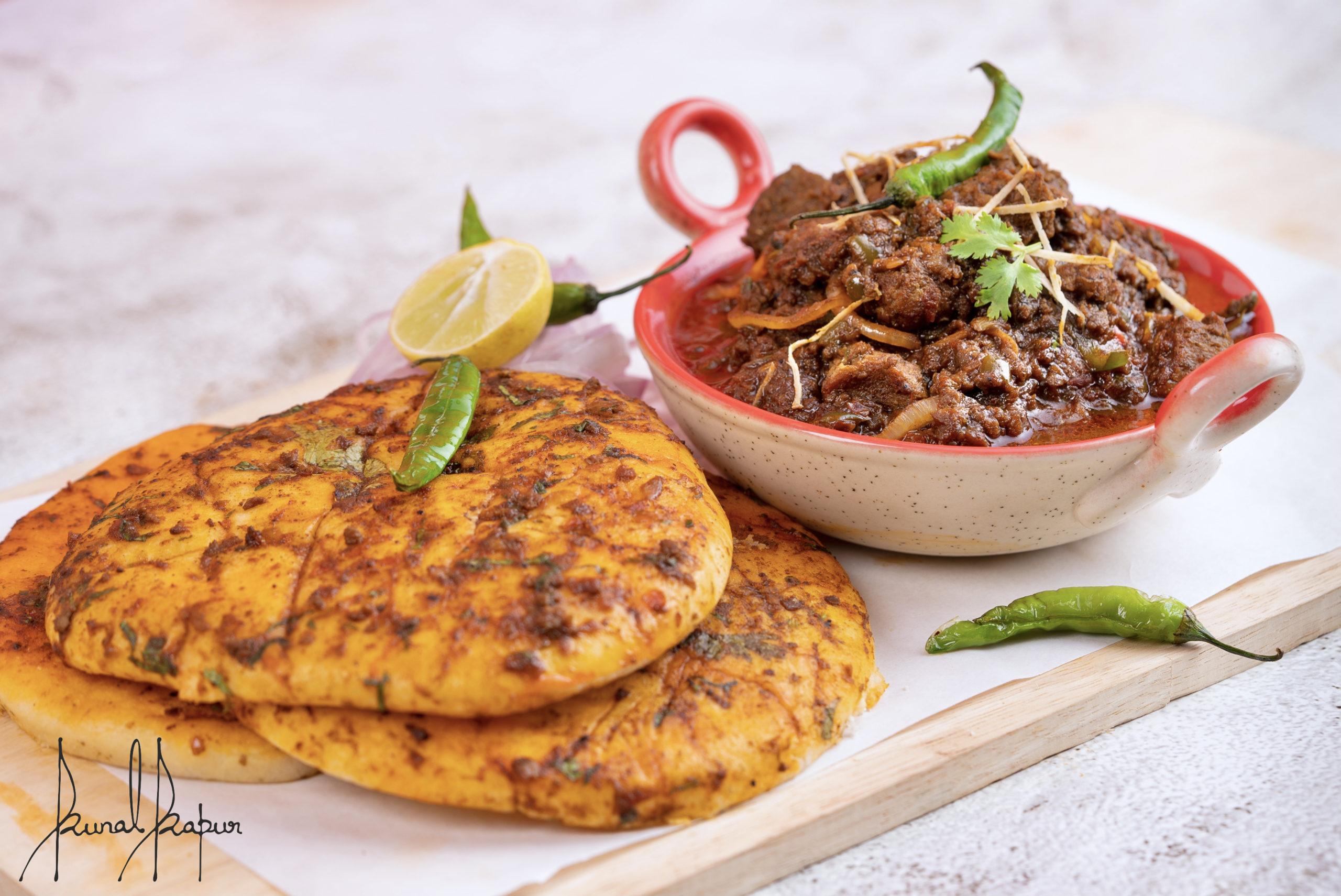 Delicious Punjabi Chole Bhature served with green chilies and lemon